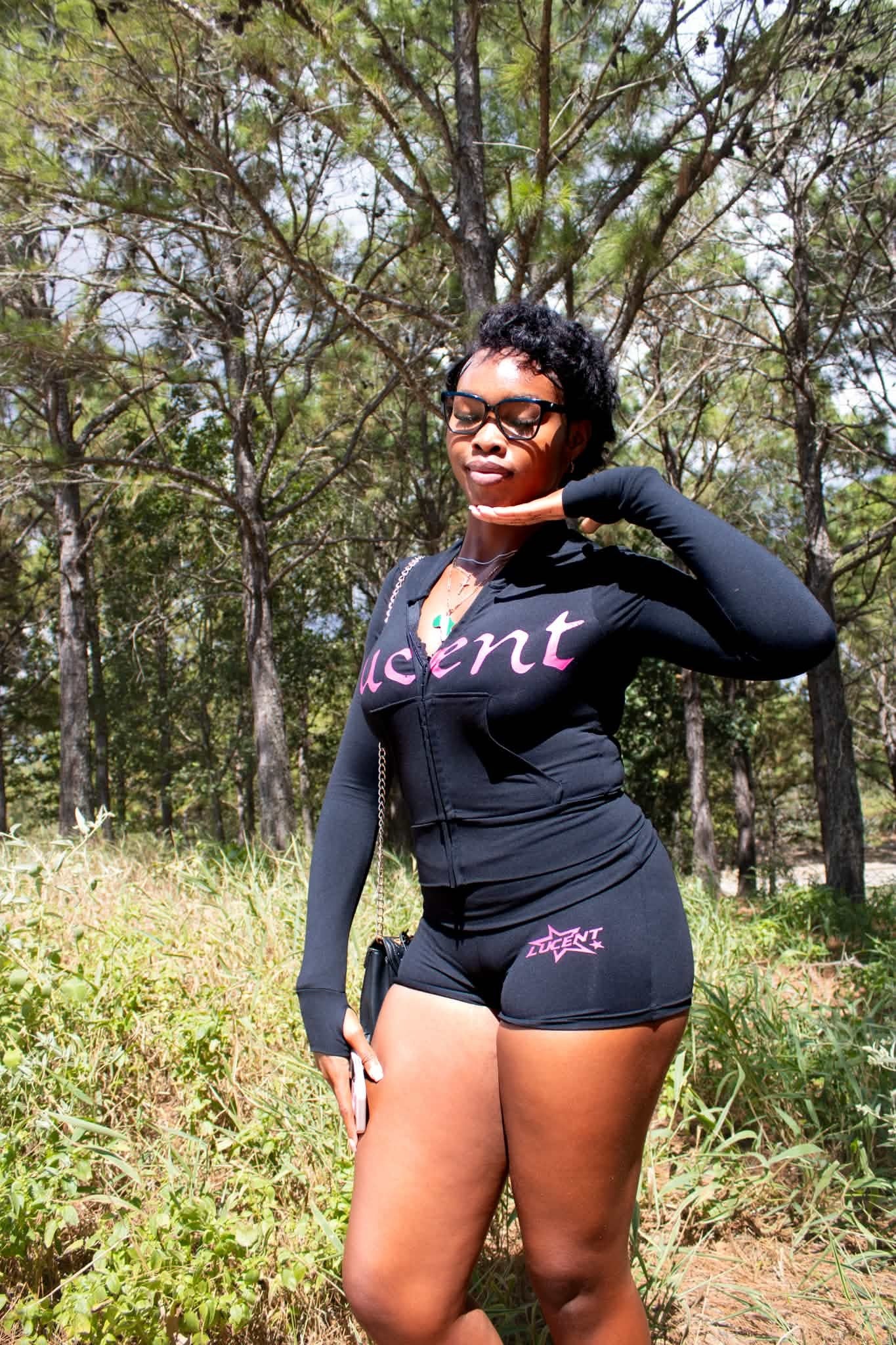 Model wearing the Lucent black zip set with pink accents